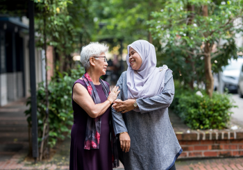 Senior Helpers franchise caregiver walking with senior client on a sidewalk